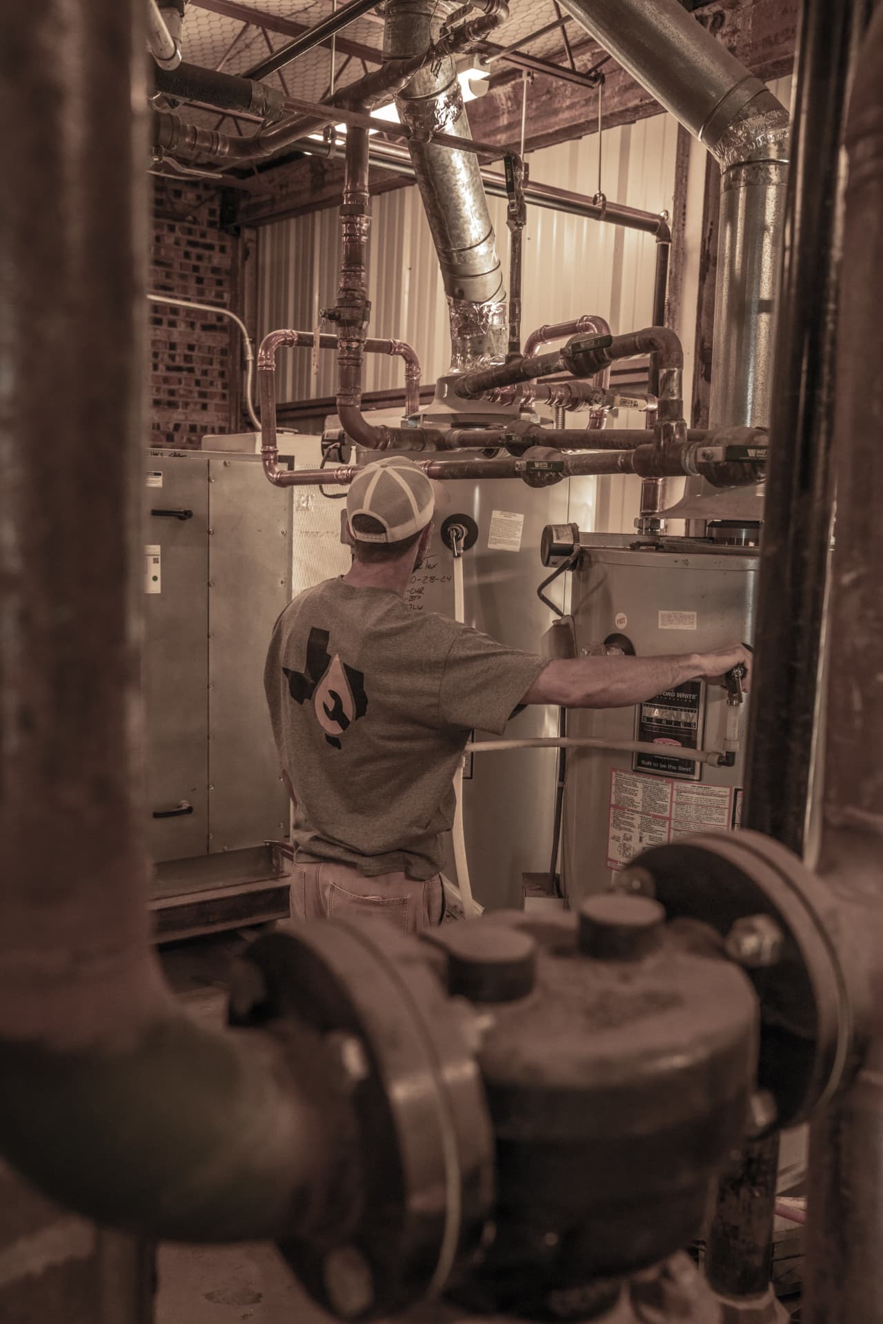 True Tex technician servicing a commercial water heater and copper piping